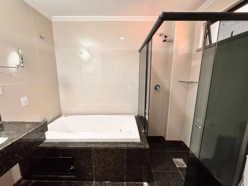a bathroom with a bath tub and a shower at Villa Nautilus Be Happy in Fortaleza