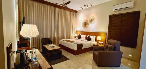 a hotel room with a bed and a chair at Villa Escape In in Kuilapayam