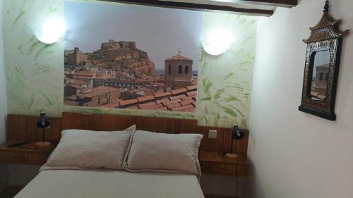 a bedroom with a painting on the wall with a bed at Pensiòn ISASA in Arnedo