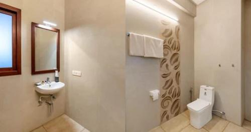 a white bathroom with a sink and a toilet at Villa Escape In in Kuilapayam