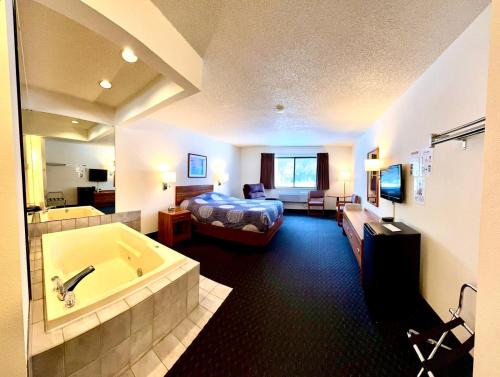 a hotel room with a bed and a bath tub at Boulder Junction Motor Lodge in Boulder Junction