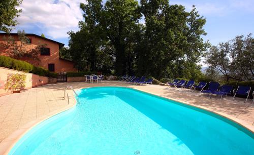 a blue swimming pool with chairs and a house at Malvarina in Capodacqua