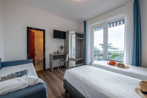ein Hotelzimmer mit zwei Betten und einem Fenster in der Unterkunft Real Park Hotel in Cavi di Lavagna