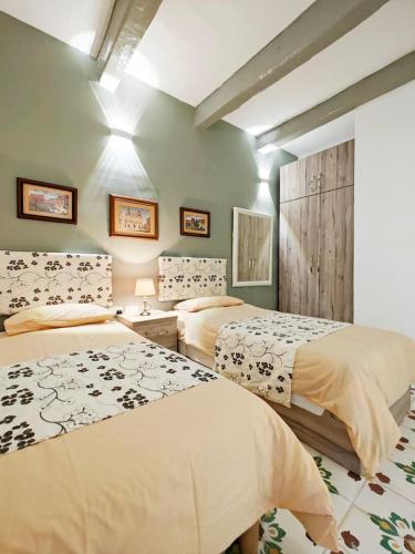 two beds in a room with green walls at Dar Marija in Valletta