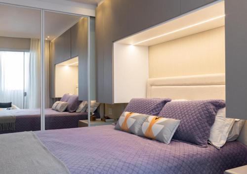 a bedroom with two beds and a large mirror at Metropolitan Sidney in Goiânia