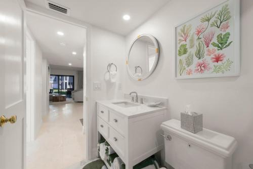 a white bathroom with a sink and a mirror at Mariner Pointe #521 in Sanibel