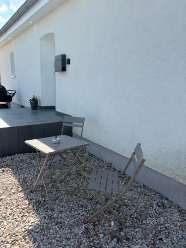a table and a chair in front of a building at Ruhige Ferienwohnung mit Waldblick in Horn-Bad Meinberg