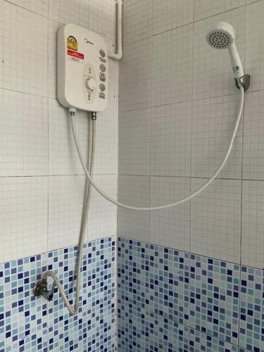 a shower in a bathroom with blue and white tiles at Elephant garden2 in Trat