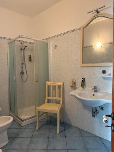 a bathroom with a sink and a shower and a chair at Hellas Makari B&B in Macari