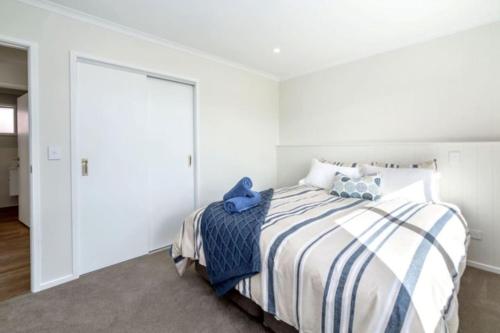 a white bedroom with a bed and a door at Arthurs Vineyard - Sleeps 10 in Martinborough