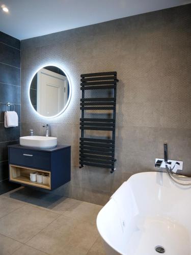 a bathroom with a tub and a sink and a mirror at Dingle Doorstep - Town Centre in Dingle