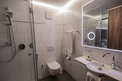 uma casa de banho com um chuveiro, um WC e um lavatório. em Hotel7Continents em Neutraubling