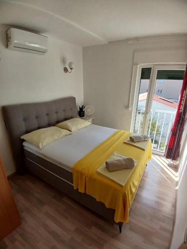 a bedroom with a large bed with a yellow blanket at Villa Ani in Novalja