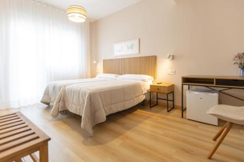 a bedroom with a large bed and a desk at Hotel Ros Mary in Ribadeo