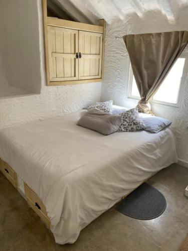 a bedroom with a large white bed with a window at Estudio Aryas nest 2 in Mijas