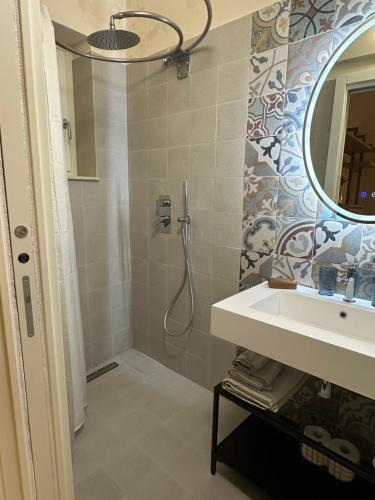 a bathroom with a shower and a sink and a mirror at Romantico bilocale ad Ortigia in Syracuse