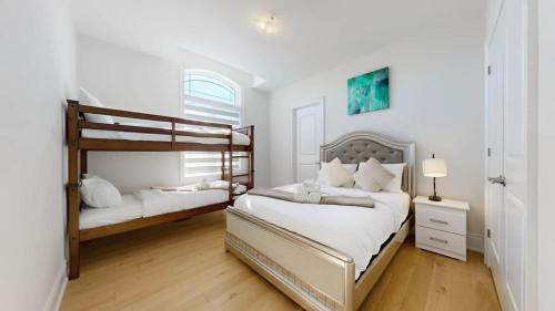 a white bedroom with two bunk beds in it at Modern-Detached 5 Bedroom100 Spotless-Sleeps 13 in Caledon East