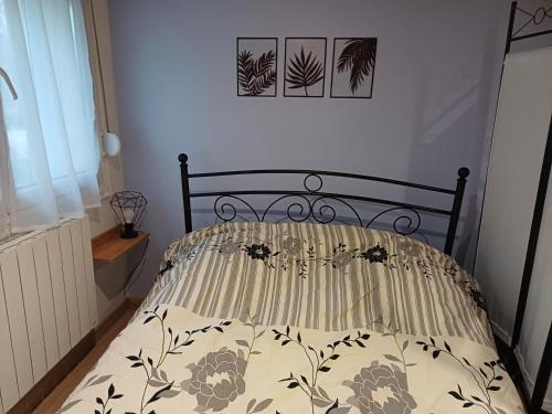 a bed with a comforter on it in a bedroom at Charmant studio au rez de chaussée in Arbois