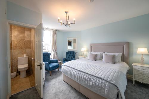 a bedroom with a bed and a blue chair at Abbey View Townhouse in Youghal