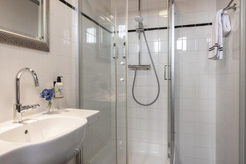 a white bathroom with a shower and a sink at Logementen Dokkum in Dokkum