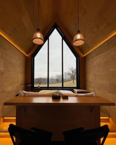 a room with a table with two chairs and a large window at PORTAL Village Only Adults in Sibiel