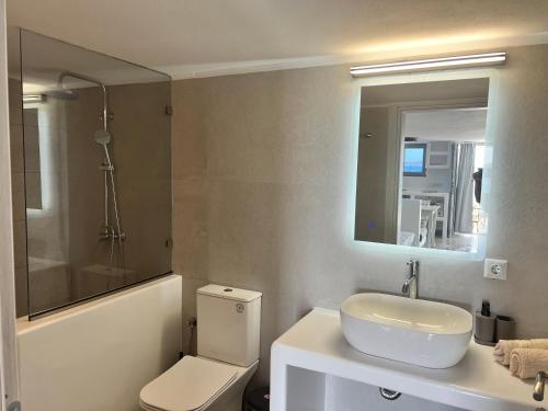 a bathroom with a toilet and a sink and a mirror at Daphne in Naousa