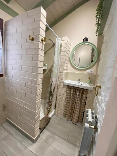 a bathroom with a shower with a sink and a mirror at La Casuca ONE De Lebeña in Lebena