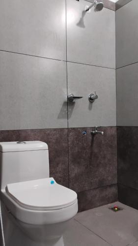 a bathroom with a toilet and a shower at Thomson Kylas Rooms in Ettumānūr