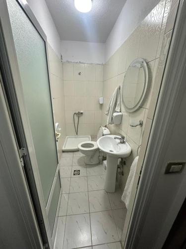 a bathroom with a toilet and a sink and a mirror at Hotel Yjet in Pogradec