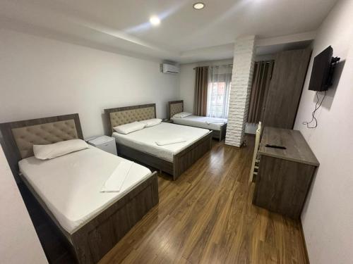 a small room with two beds and a desk at Hotel Yjet in Pogradec