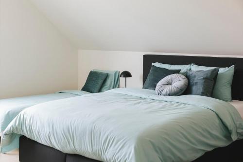 a bedroom with a large bed with a pillow on it at Vakantiewoning 't Veld in Ledegem