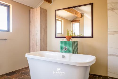 a white bath tub in a bathroom with a mirror at Boardwalk in Britannia Bay