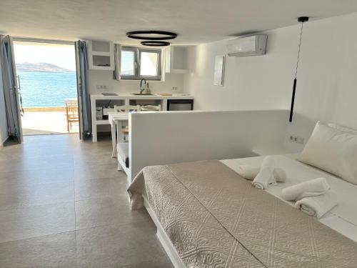 a bedroom with a bed and a kitchen and the ocean at Daphne in Naousa