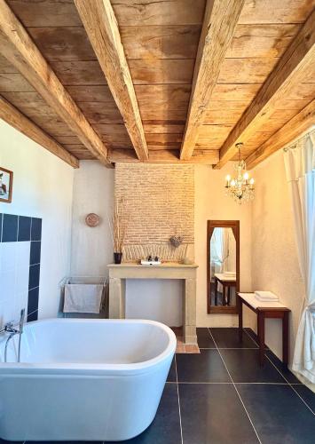 a large bathroom with a tub and a table at "La Maison de Villars" au coeur de la nature in Pressac