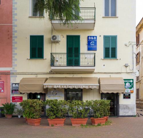 a building with plants in front of a store at Prima Classe Battipaglia in Battipaglia