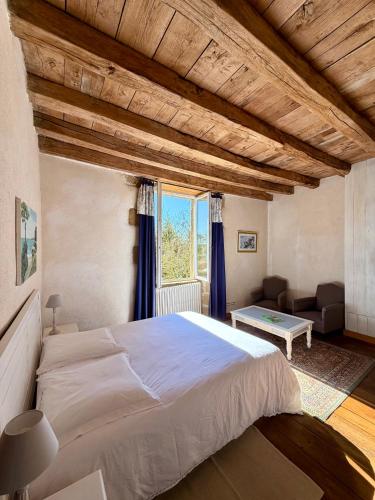 a bedroom with a large bed and a large window at "La Maison de Villars" au coeur de la nature in Pressac