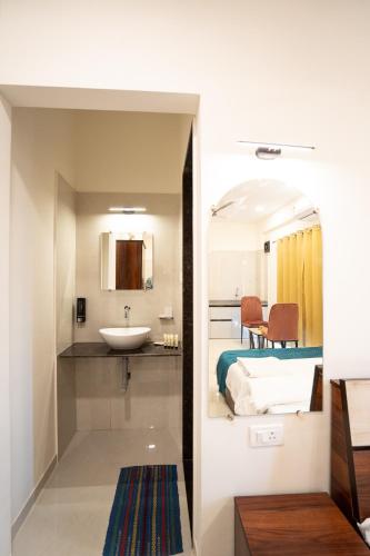 a bathroom with a sink and a bed in a room at 46 Elite Enclave in Nashik