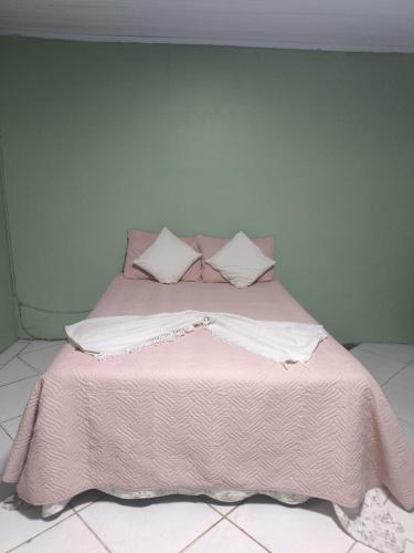 a bed with a pink blanket and pillows on it at Espaço Vip in Brasília