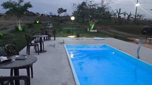 a swimming pool with tables and chairs next to a yard at Espaço Vip in Brasília