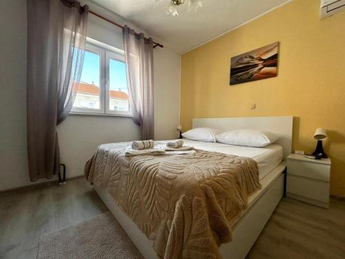 a bedroom with a bed and a window at Guest House Angela in Senj