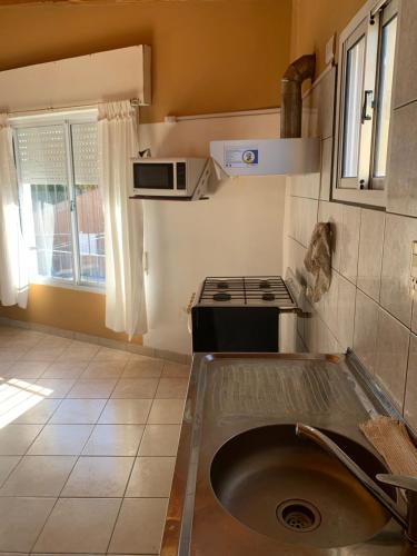 a small kitchen with a sink and a stove at Apart Cerezos in Los Antiguos