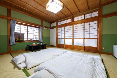 a bedroom with a large bed in a room with windows at Yoshinogun - House - Vacation STAY 17051 in Yoshino