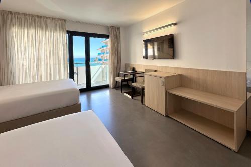 a hotel room with a bed and a desk and a television at Hotel Acuazul in Peniscola
