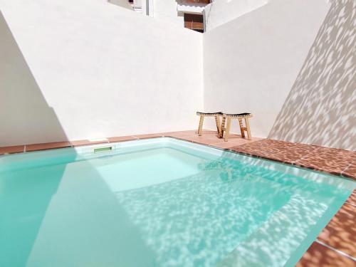 a swimming pool with two chairs in a building at Bo&Co Apartments in Sitges