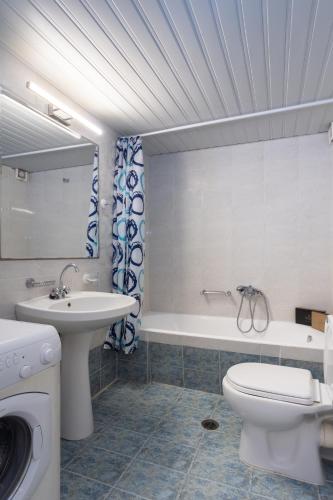 a bathroom with a toilet and a sink and a tub at Galaxy Rooms in Paralio Astros