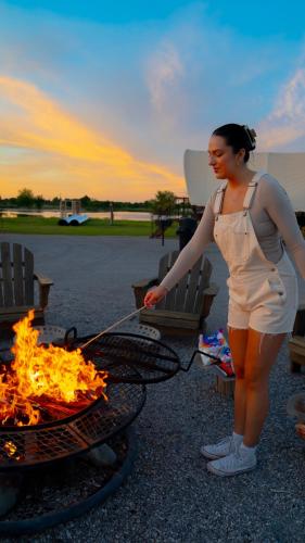 a woman is standing next to a fire at Orr Family Farm & RR, LLC in Oklahoma City