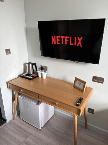 a wooden desk with a netflix sign on a wall at Hamilton House, Chester in Hope