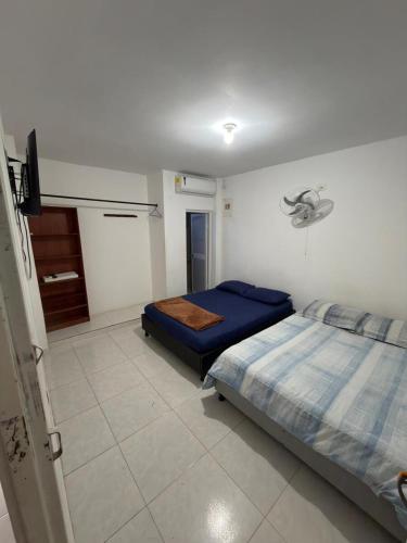 a bedroom with two beds and a tv in it at HOSTAL CARACOLI - HUECO in Valledupar