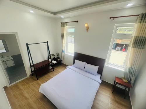 a bedroom with a white bed and two windows at villa danisa hoa in Khu Chi Lăng