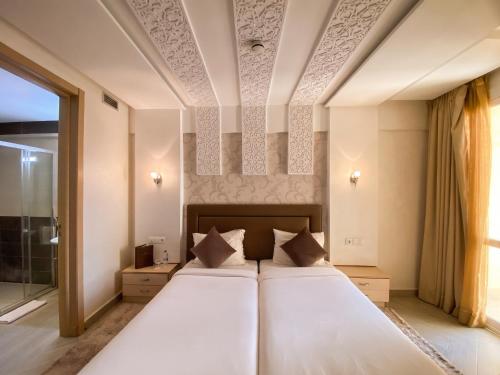 a bedroom with a large bed and a window at Résidence La Place in Laayoune